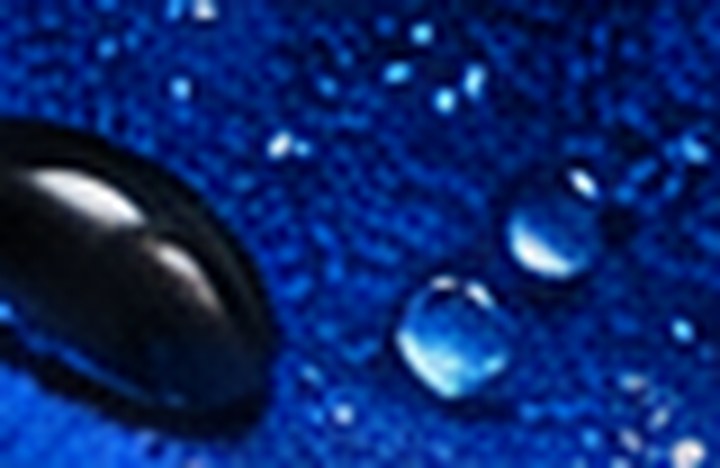 Close-up of cobalt technical fabric with water beading on the weave